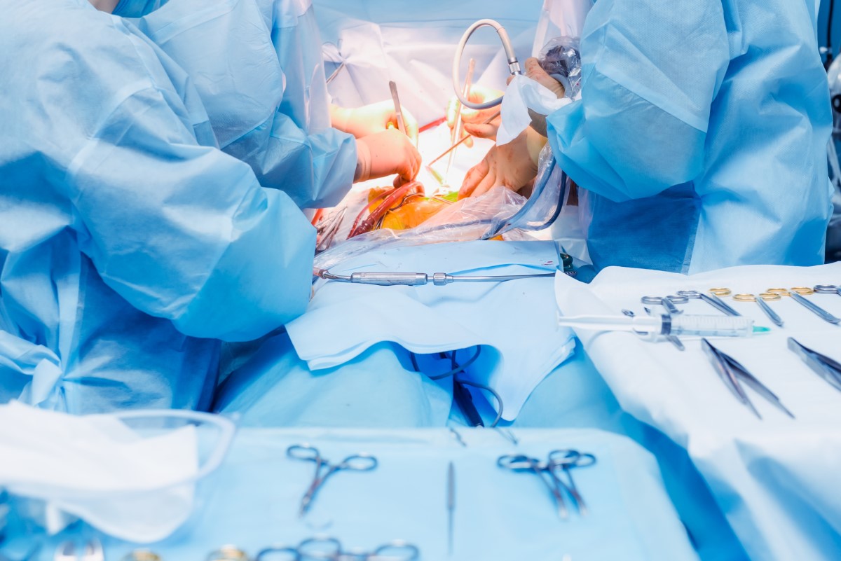 Chirurgická léčba – břišní operace a lékaři a zdravotníci na operačním sále operují pacienta