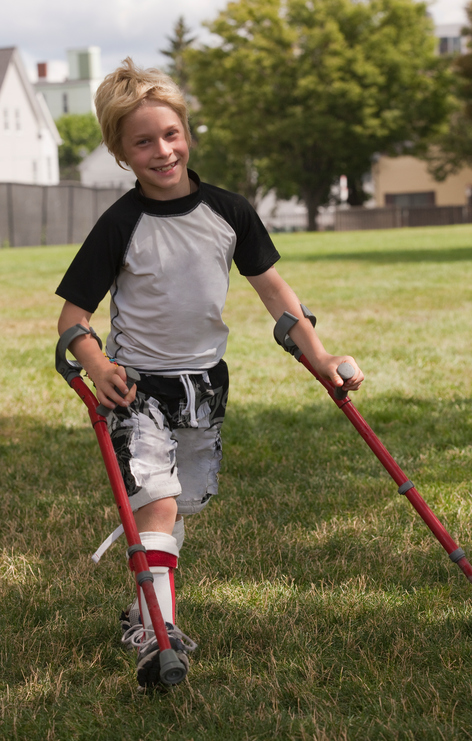 Dítě s dětskou mozkovou obrnou a protetickou pomůckou na chůzi. 
