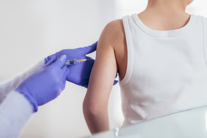 Očkování - lékař píchá dítěti vakcínu 