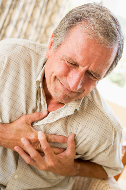 Starší muž si drží hrudník v oblasti srdce, má palpitace, čili bušení srdce a stenokardie, tedy bolest na hrudi