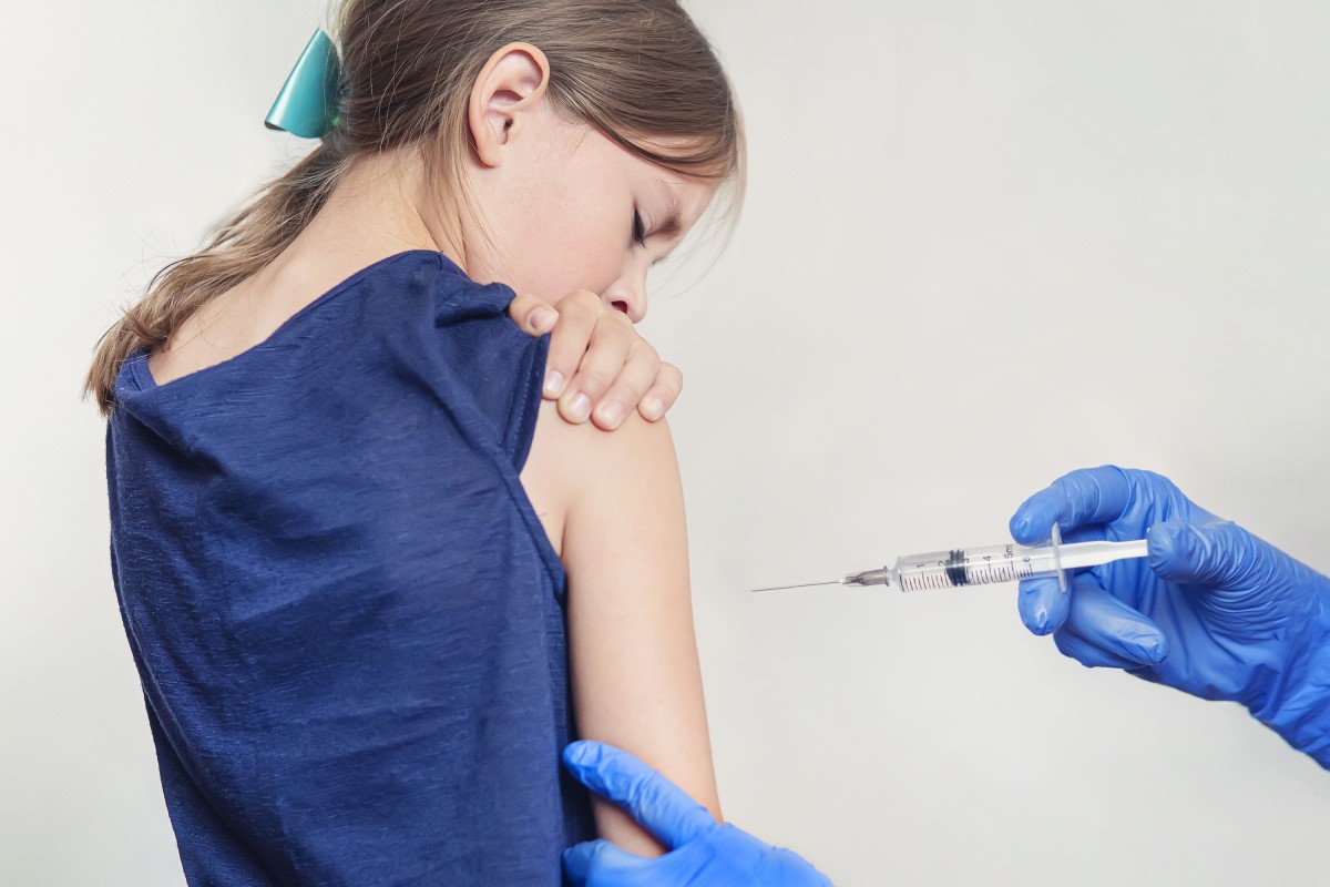 Očkování dítěte - dívky - lékař píchá vakcínu do ramene