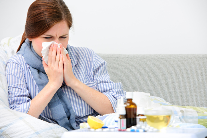 Nemocná žena má chřipku, rýmu, zánět horních cest dýchacích, kapesníky, léky