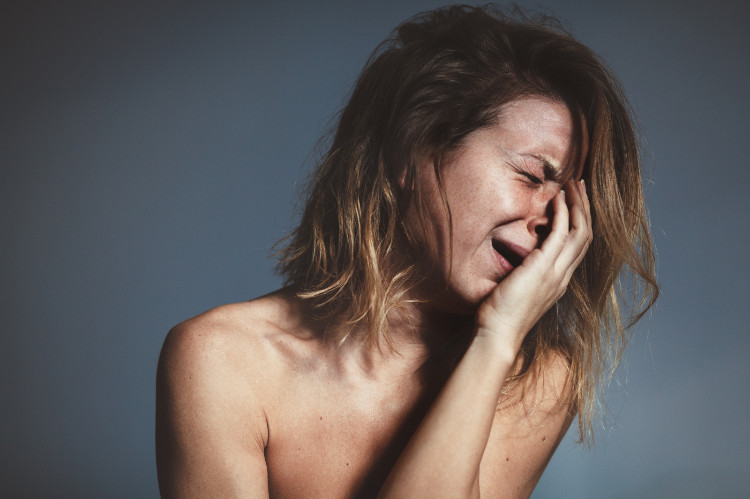 žena v záchvatu pláče si rukou drží tvář