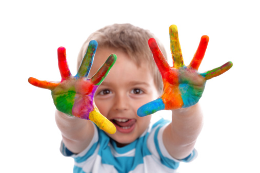 Chlapeček ukazující ruce do objektivu zašpiněné barvami