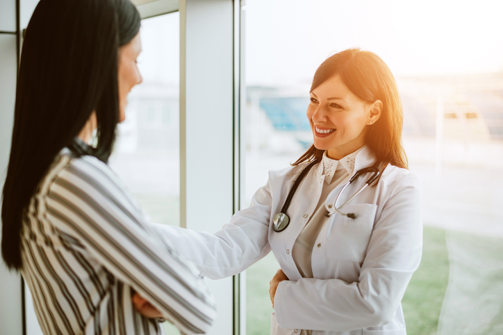 Doktorka s úsměvem komunikuje s pacientkou