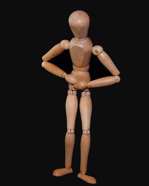 Drevená figurka si drží bricho jako znak bolesti bricha