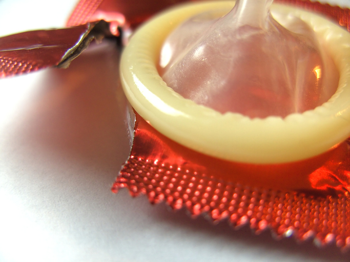 Kondom vyjmutý z obalu, roztržený obal, jako prevence kapavky a jiných pohlavně přenosných onemocnění, bariérová antikoncepce