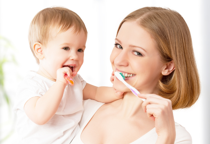Matka si spolu s dítětem na rukou čistí zuby.