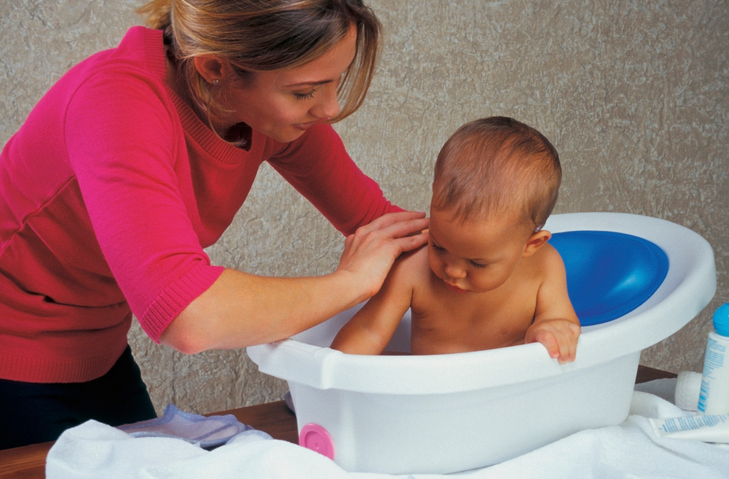 Matka koupe dítě ve vaničce