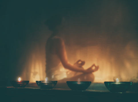 žena medituje při svíčkách
