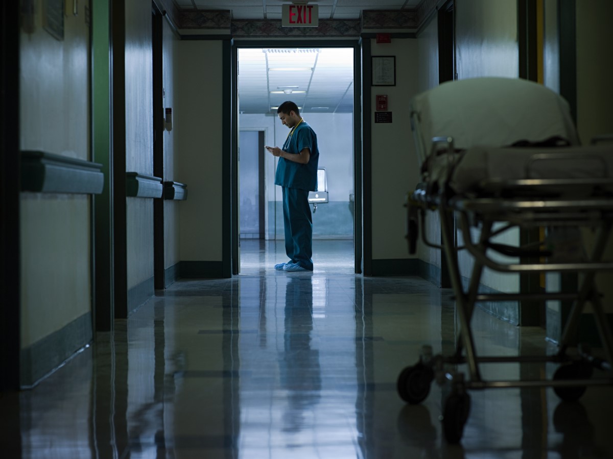 Noční práce a její vliv na poruchy cirkadiánního rytmu - Příkladem je noční práce zdravotníků - lékař stojící na chodbě nemocnice.