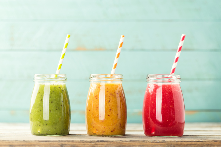 Tři barevné sklenice ovocného smoothie brčka - zelené, žluté a červené