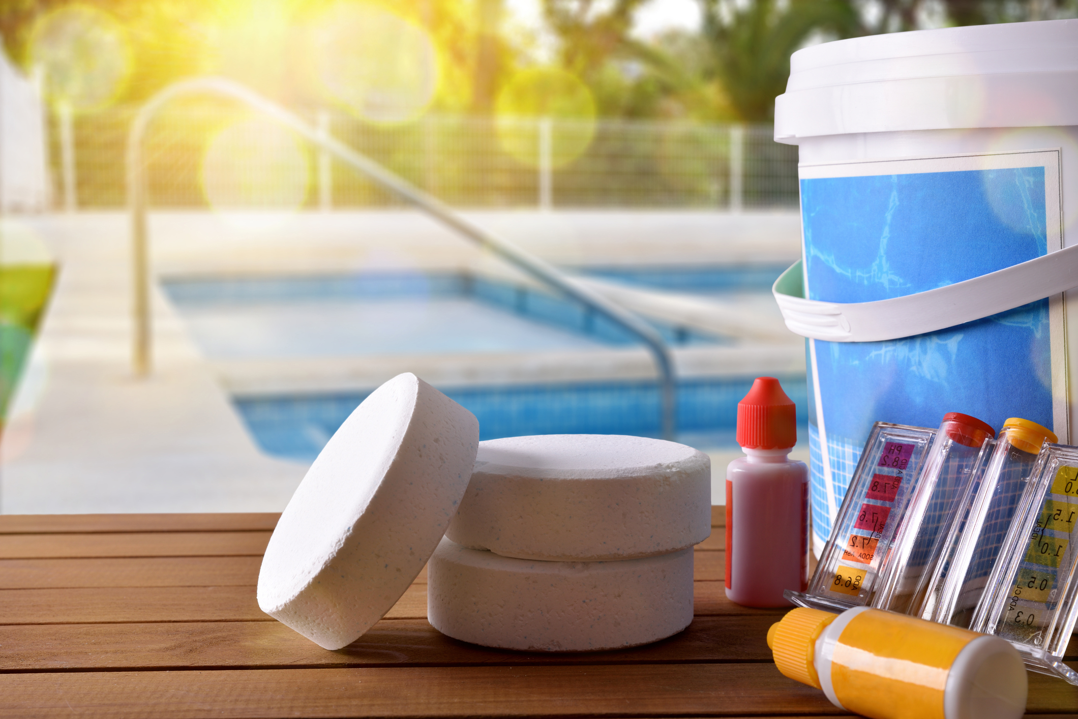 Přípravky a chemikálie pro ošetření vody v bazénu, bazén v pozadí