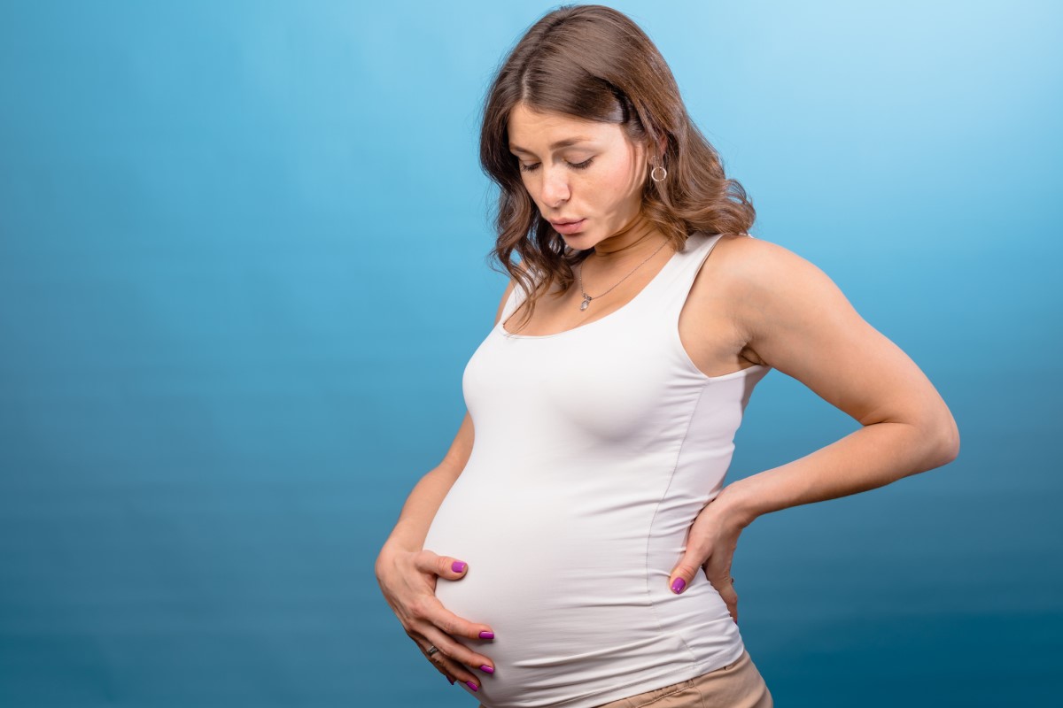 Těhotná žena si drží břicho