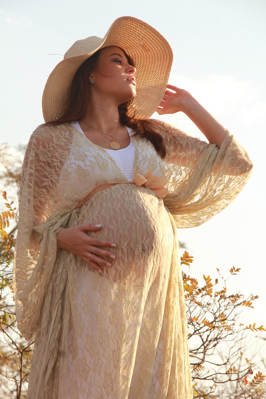 Těhotná žena, oblečené šaty a klobouk