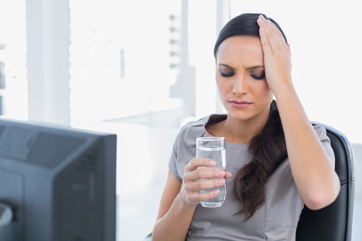 Žena má bolesti hlavy pri vážné dehydrataci
