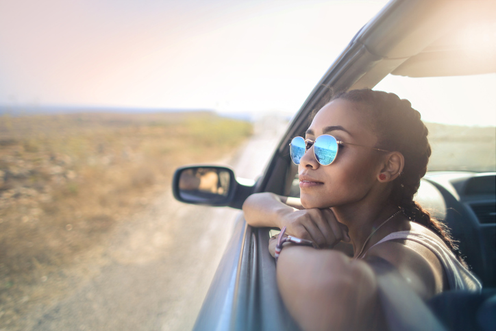 Žena ve slunečních brýlích v okně auta