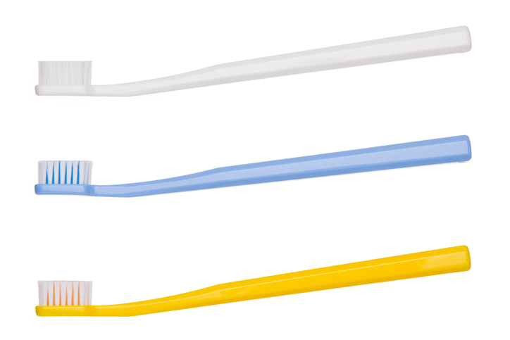 Tři vhodné zubní kartáčky, bílá nahoře, uprostřed modrá a spodní žlutá