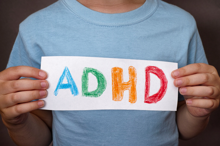 Chlapec drží tabulku s barevným nápisem ADHD
