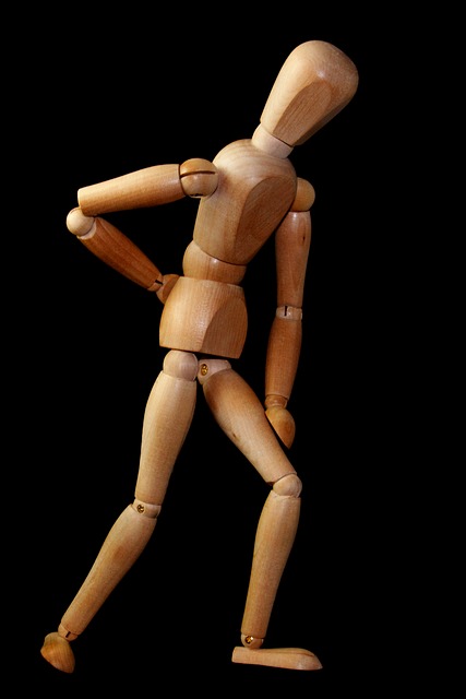 Dřevěný model panáka, ukazuje na bolest kříže
