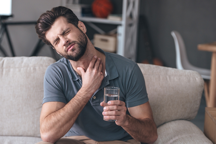 Muž má bolest v krku - zhoršuje ji pití vody
