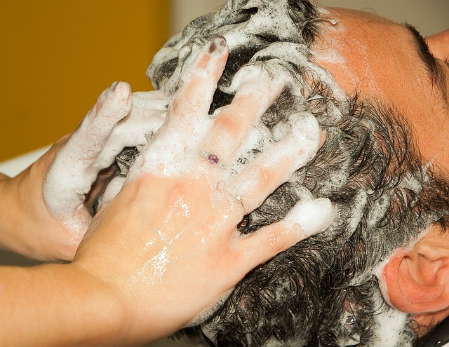 muži myjí vlasy a má našampónovanou hlavu, ruce ve vlasech