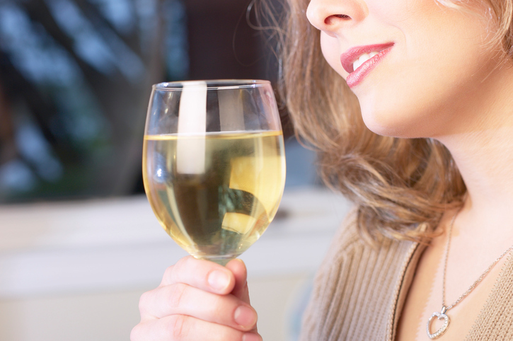 Žena popíjí alkohol, víno ve sklenici, výřez ženské tváře - nos a ústa, v ruce drží pohár. Dlouhodobý alkoholismus jako příčina poruchy polykání